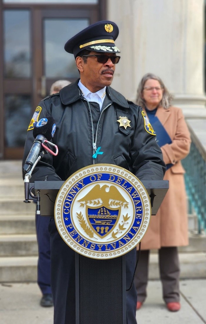 Sheriff Sanders at a podium with the County seal on it